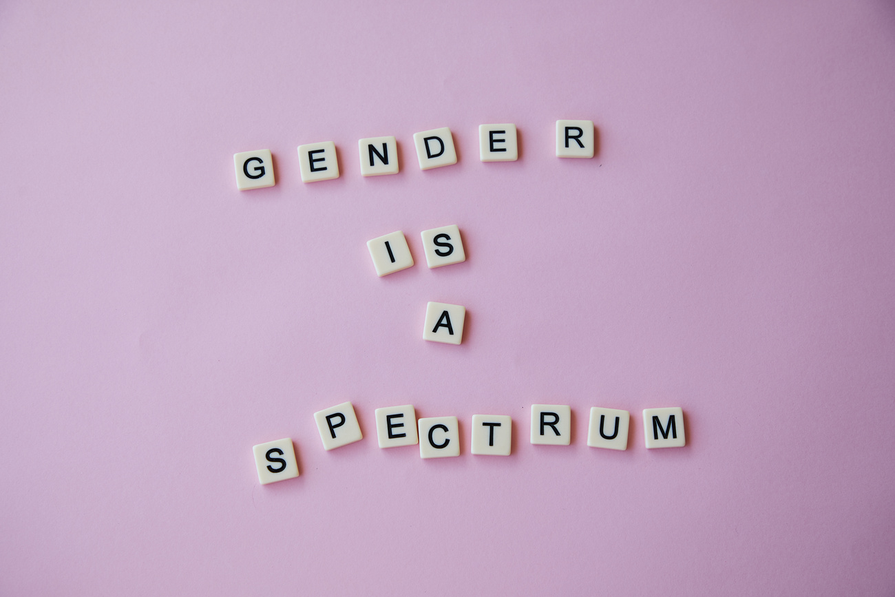 Inscription Gender is a spectrum made of scrabble letters against pink background